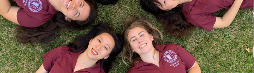 student orientation leaders laying in circle on grass